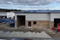 Current exterior construction progress of Unit 2, showing the modern structural framework and new cladding being installed on the commercial unit.